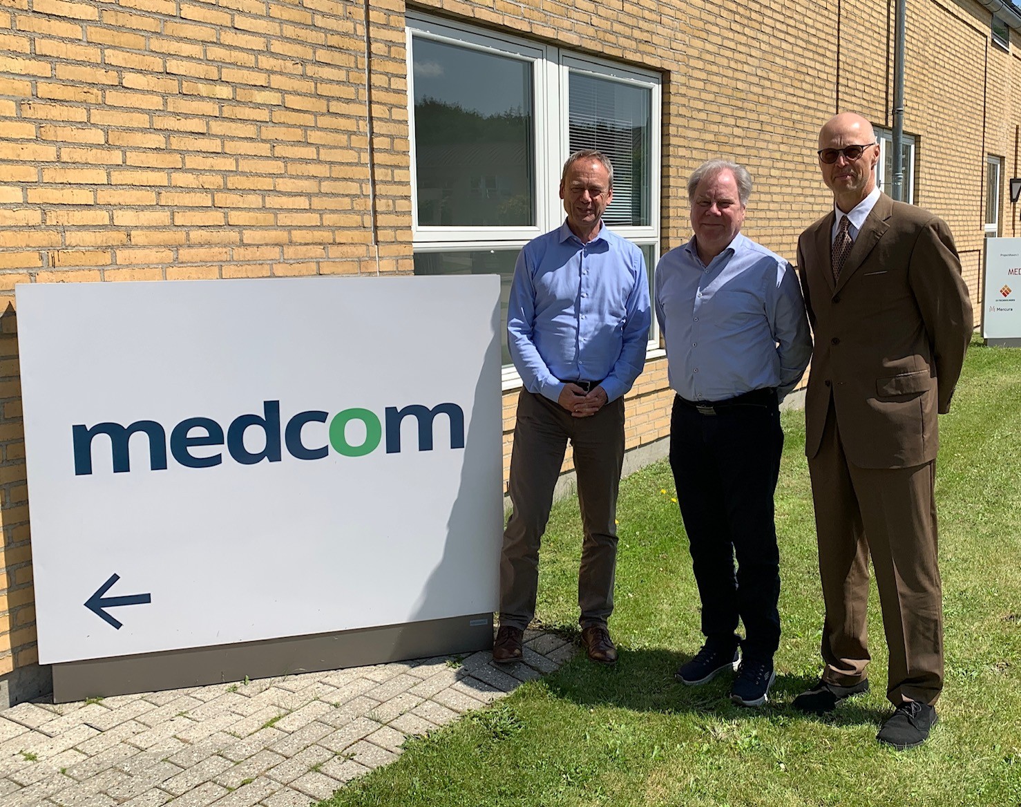 MedComs kvalitetskonsulent Tomas Platatka sammen med auditør og Lars Hulbæk foran MedCom-skiltet i Forskerparken.
